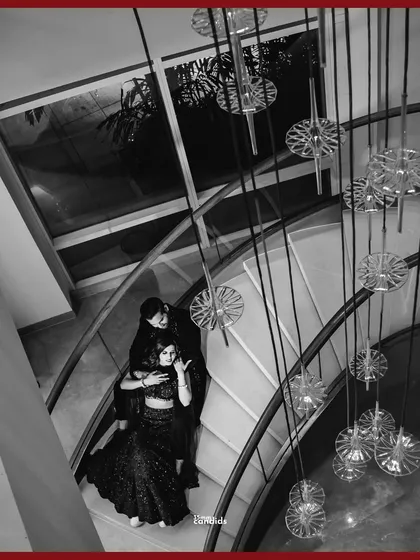 A dramatic, high-angle black and white shot of the couple on a grand staircase. This architectural portrait from their reception feels both modern and timeless.