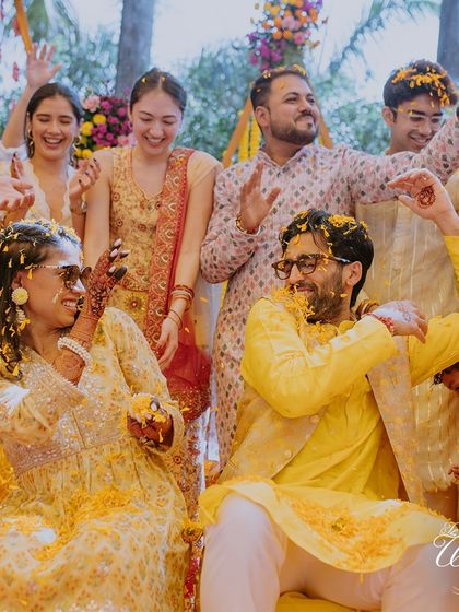 The couple and their friends dancing together under a shower of petals. This image is pure, unadulterated joy and celebration.