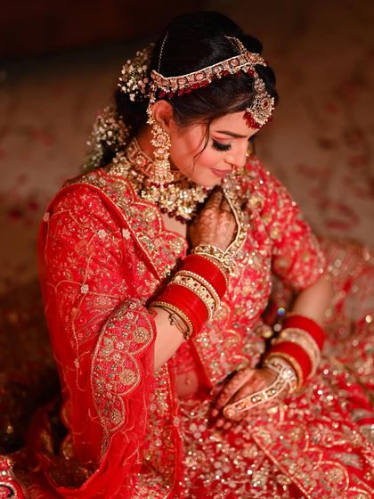 A beautiful profile shot of the bride, highlighting her intricate hairstyle with flowers and her elegant jewelry.