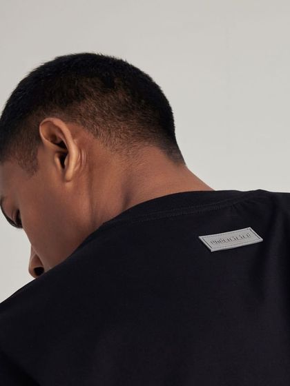 A shot focusing on the branded tag on the back of an Understated t-shirt, highlighting quality details.