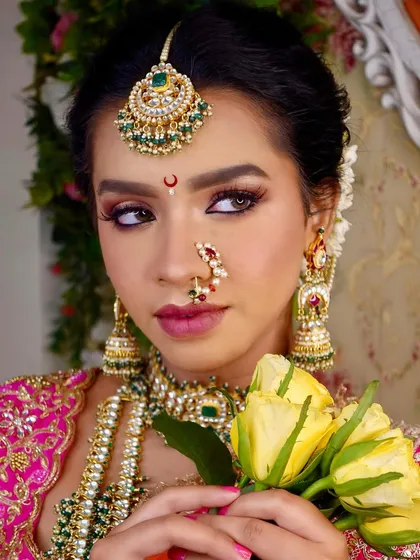 A beautiful portrait of the Maharashtrian bridal look, highlighting the intricate details of the nath and maang tikka.