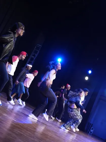 Dancers in motion during a stage run-through. The angled shot captures the dynamic movement and synchronicity of the group.