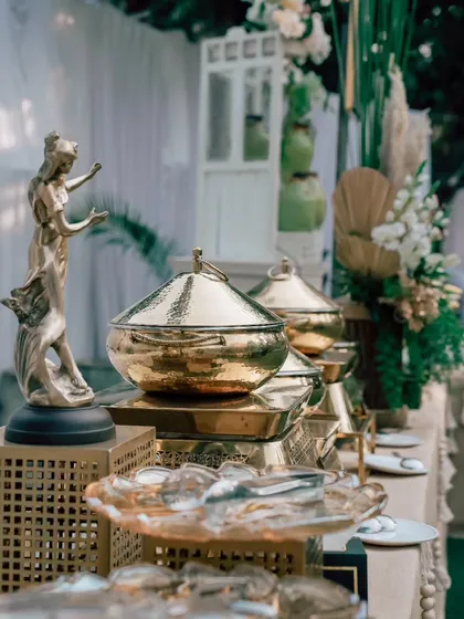 A close-up of the luxurious details on my buffet counter, including hammered golden serving bowls and artistic statuettes that elevate the food display.