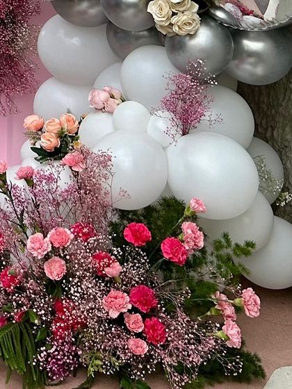 A detailed shot of the balloon and floral arrangement. I carefully weave fresh flowers like roses and baby's breath into the balloon garlands to add texture, sophistication, and a touch of nature to the decor.