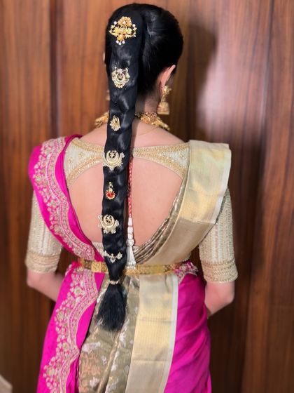 The full view of a stunning ponytail braid adorned with traditional gold hair ornaments, a unique and stylish option for a modern bride.