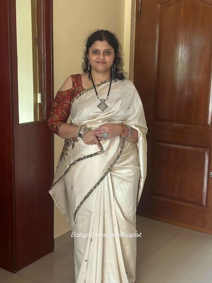 A happy client ready for an Onam celebration. The off-white saree is draped in a simple, classic style that is both elegant and comfortable for a festive gathering.