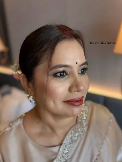 A close-up of her makeup, showing the soft kohl-rimmed eyes and glossy nude lips. A timeless and sophisticated look.