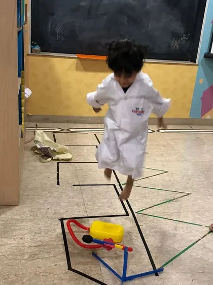 A student jumps with excitement as he prepares to launch his rocket. It's pure joy and learning combined.