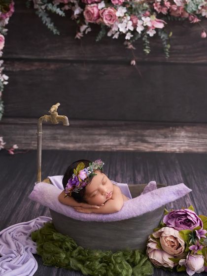 We styled this unique shot with a baby sleeping in a miniature tub, complete with a vintage tap and surrounded by purple peonies for a whimsical bath time portrait.