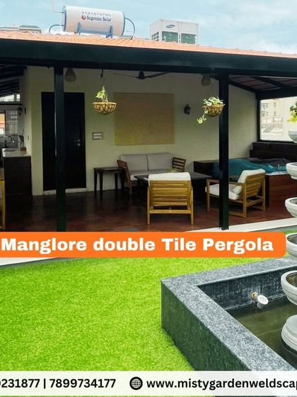 We create outdoor spaces that are both beautiful and functional. This terrace features a classic Mangalore double tile pergola for excellent heat insulation, paired with a low-maintenance artificial lawn and a calming water feature, creating a complete outdoor living experience.
