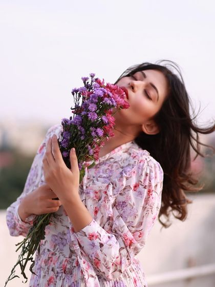 Lost in the beauty of nature. This portrait, with her face buried in a bouquet of wildflowers, is a celebration of sensory joy and peace.