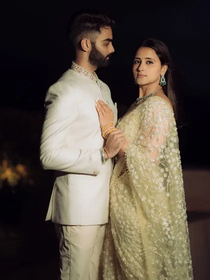 A dramatic, high-fashion pose against a dark background. This shot from a rooftop engagement in Mumbai highlights the couple's stylish outfits and creates a modern, edgy, and cinematic feel.