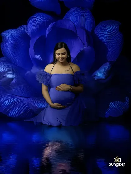 A dramatic low-key portrait with a giant blue flower and a water reflection effect, creating a moody and artistic image.