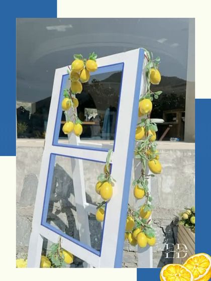 A decorative ladder draped with lemon vines, set against a blue and white graphic background, reinforcing the event's core design elements.