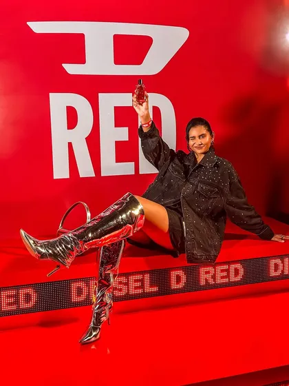 A dramatic pose on a branded installation at the Diesel event, creating a powerful visual for the new D-RED fragrance.