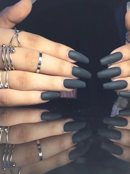 A bold and dramatic set of long, matte black nails on square-shaped extensions.