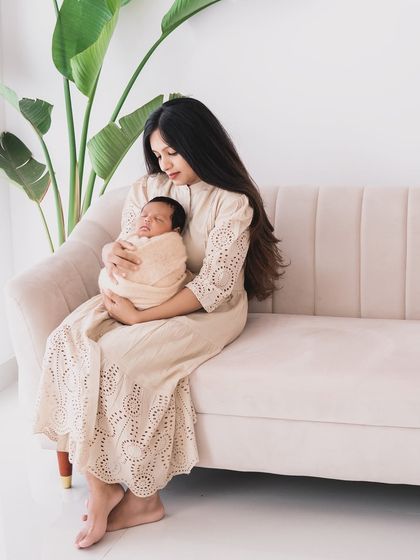 A lifestyle family portrait with a newborn on the sofa. These sessions capture your new life at home.