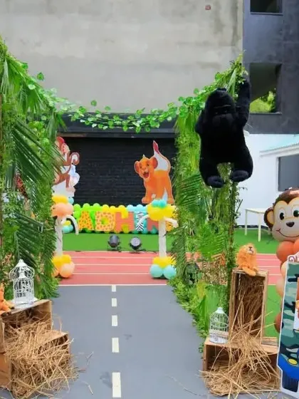 An elaborate jungle safari entrance, complete with a leafy arch, animal cutouts, and a jeep photo booth.