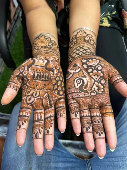 This party-style mehandi features beautiful peacock figures on both palms. The use of negative space makes the peacocks the central focus of the design.