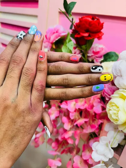 A full view of both hands, showcasing the complete set of random nail art.