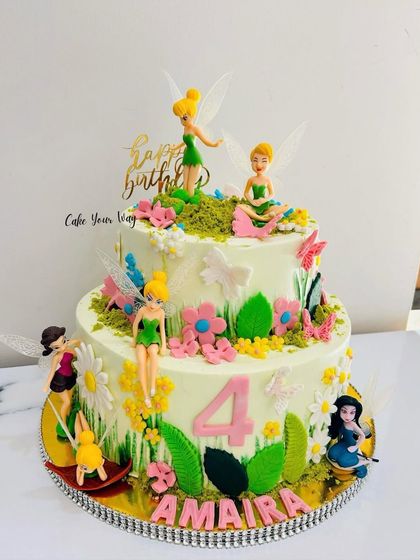 A magical two-tier fairy cake with delicate wings, flowers, and a whimsical garden theme for Amaira's 4th birthday.