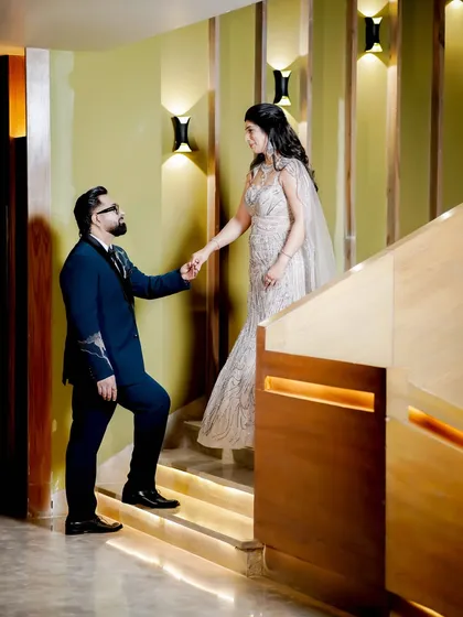A beautifully composed shot on a staircase, capturing a chivalrous moment between the couple.
