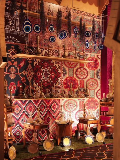 Another view of the artifact market, with hanging evil eye charms, brass hookahs, and patterned textiles creating a rich tapestry of cultural objects.