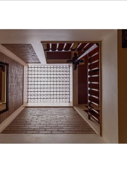 An abstract view of the light well, showcasing the combination of brick, wood, and a glass block jaali wall, demonstrating how different materials work together to manage light.