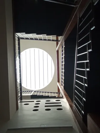 This space is one of my favorites. It features a triple-height volume that brings incredible light and airiness, anchored by a massive circular skylight and a sleek, folded-plate staircase. It's a perfect example of how I use volume and light to create a central courtyard feel.