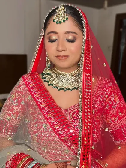 A beautiful bridal portrait. I gave her a classic look with gold and brown smokey eyes and a neutral glossy lip to complement her red and green lehenga.