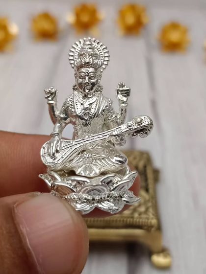 A delicate Panchaloham idol of Goddess Saraswati, the goddess of knowledge and arts, holding her veena.