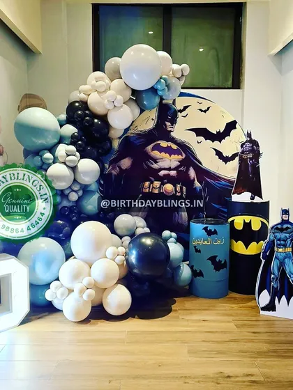 This Batman theme uses a dramatic backdrop of the Gotham city moon and bats. The setup includes a large light-up number '5' and multiple Batman cutouts for a heroic atmosphere.