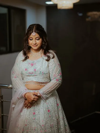 A three-quarter portrait of the bride, her hands clasped, looking serene.
