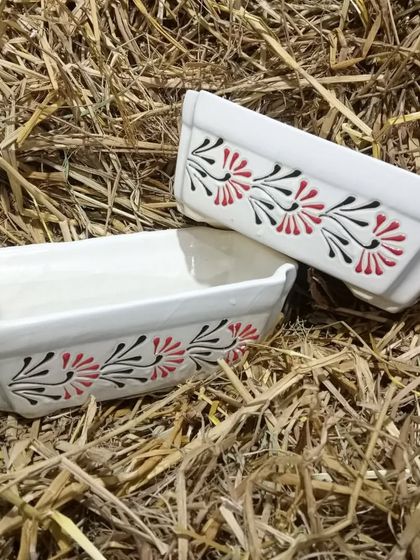 A pair of rectangular ceramic planters with a hand-painted floral design. These are great for creating small arrangements of multiple succulents or for a single bonsai.