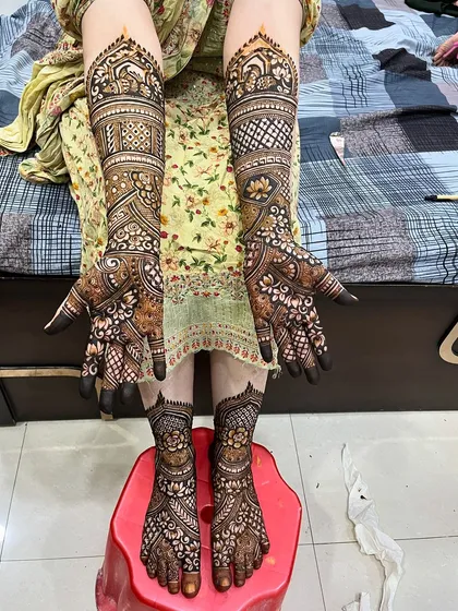 A complete view of bride Ayesha's mehndi, showing how the designs on her hands and feet create a cohesive and stunning look.