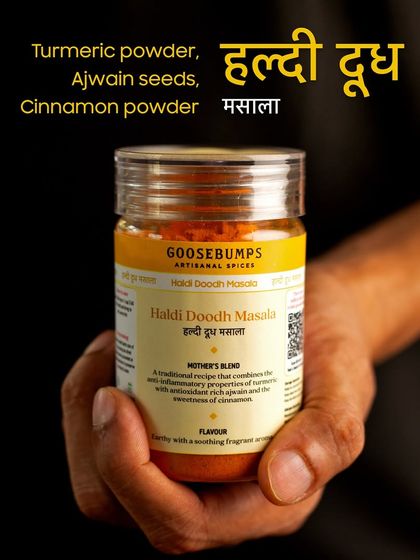 A hand holding my Haldi Doodh Masala, with its simple yet powerful ingredients listed: turmeric powder, ajwain seeds, and cinnamon powder. It's an Ayurvedic blend cherished for generations.