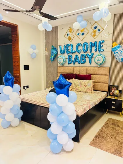 A closer view of the 'Welcome Baby' room setup, showing the balloon pillars with star foil balloons.