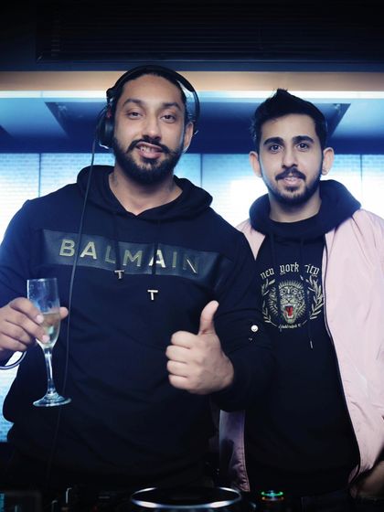 Sharing a celebratory drink with a friend at the DJ booth. Good vibes and great music go hand in hand.