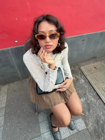 A customer looking chic and confident in our black studded ballet flats. It’s great to see how these shoes can complete a look, adding a point of interest to a pleated skirt and simple top.
