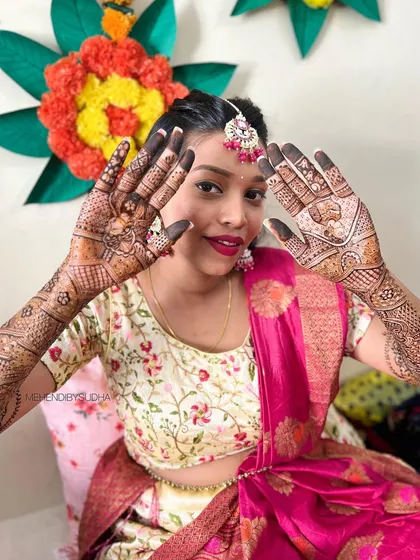 A radiant bride showcasing her full bridal mehendi, which perfectly complements her traditional attire.