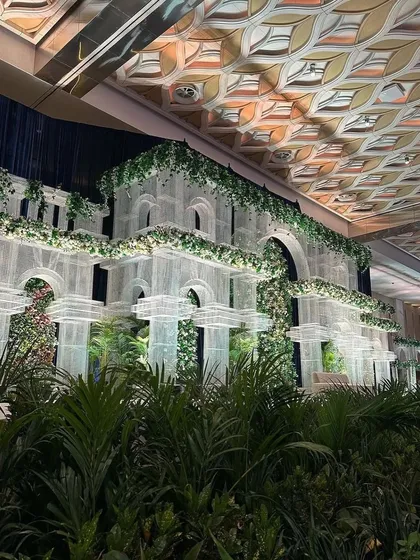 A grand architectural backdrop inspired by classic European conservatories. The structure is softened with lush greenery, creating a stunning setting for an elegant wedding.