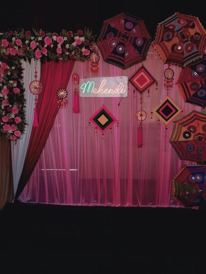A slightly different angle of the pink Mehendi setup, showing how the neon sign glows and adds a modern twist to the otherwise traditional decor elements.