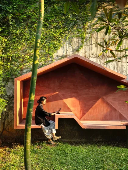A custom-designed sculptural seating installation. This piece, finished in a bold red oxide, transforms a simple garden corner into a functional work of art, perfect for a quiet moment of reflection or work.