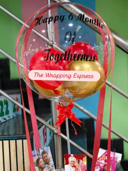 I create personalized balloon bouquets like this one for a 6-month anniversary. The clear balloon has a custom message, and the basket below can hold photos, chocolates, and other small gifts.