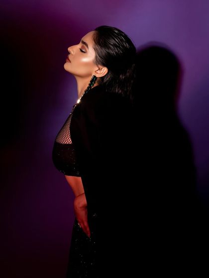 This profile portrait from the GQ feature uses shadow to create a mysterious and artistic mood, focusing on the slicked-back hair and makeup.