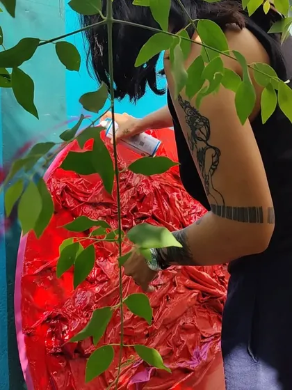 Spray painting a textured red installation, a process of reclaiming the color's energy.