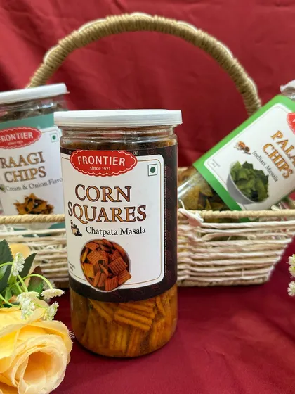 For our wedding hampers, we can include a variety of gourmet snacks like these jars of ragi chips, corn squares, and palak chips.