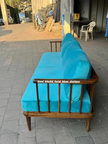 Side profile of the teak wood spindle-back sofa.