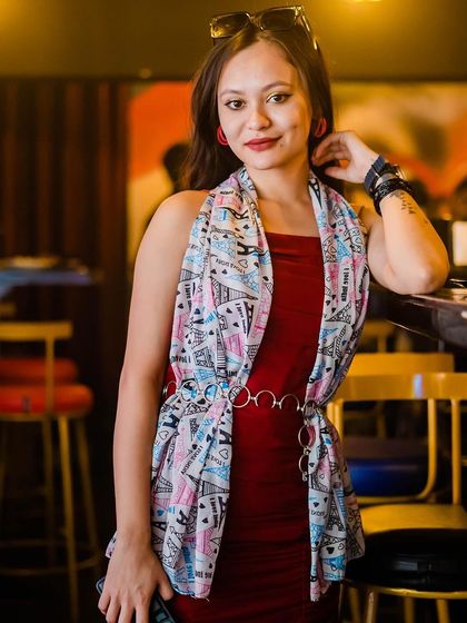 A guest in a stylish red dress and scarf.