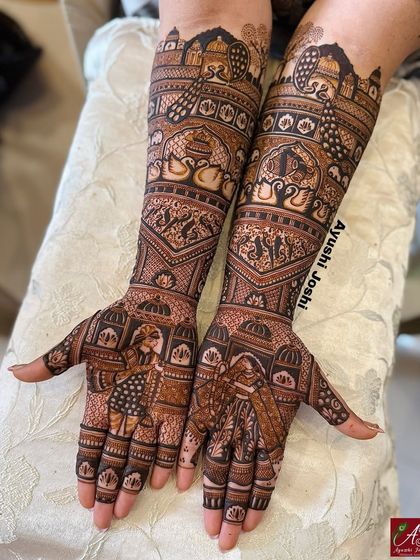 A full view of a traditional bridal design, with the bride and groom on the palms and majestic peacocks and palace architecture covering the arms.